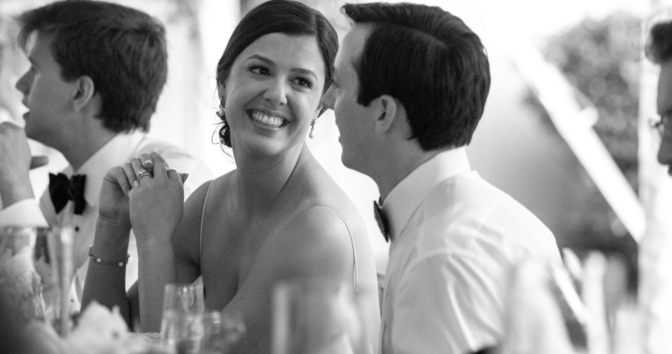 Couple at wedding table smiling at each other