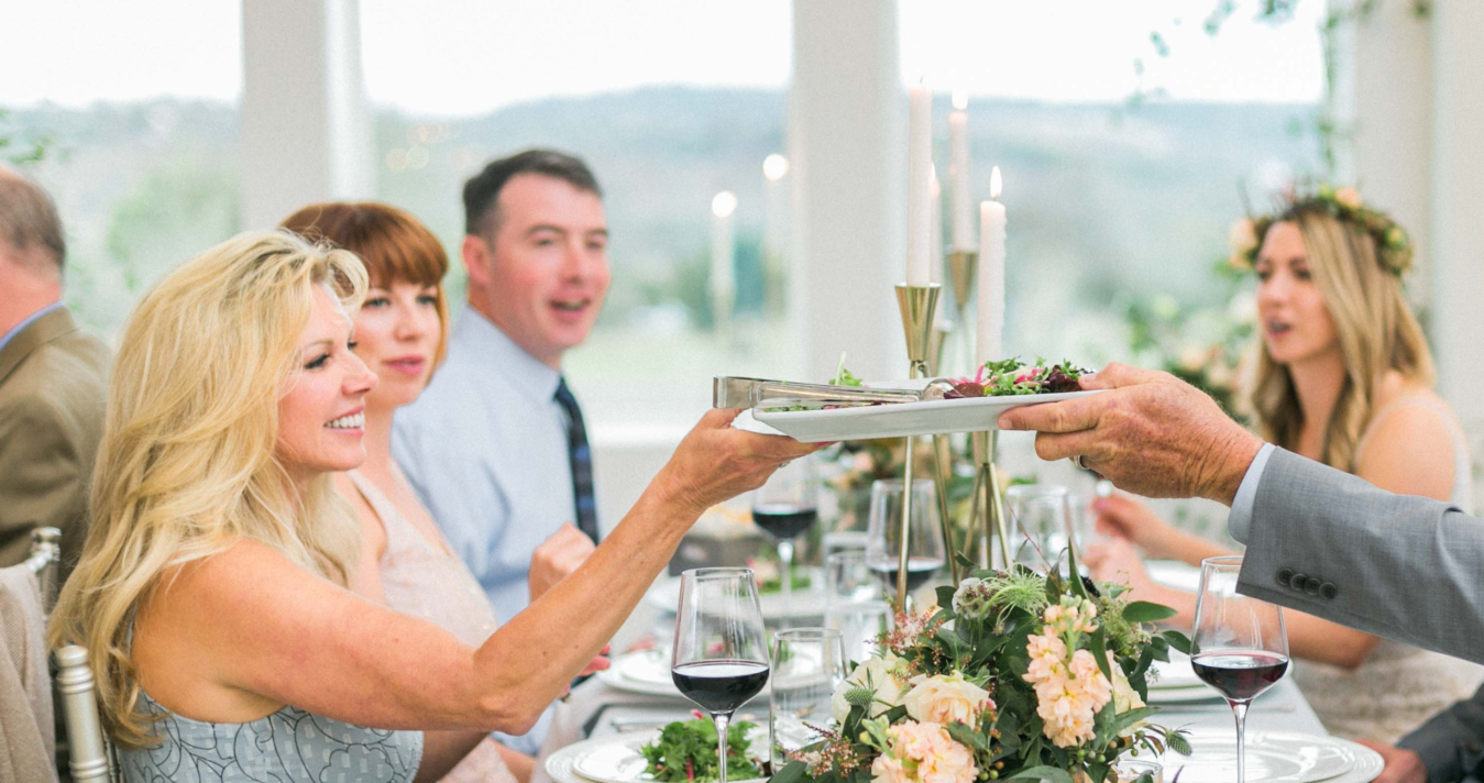 5 people sitting at table passing food