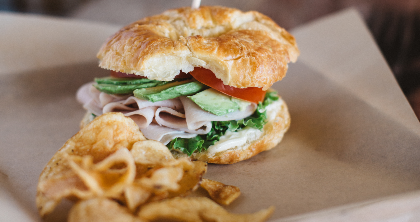 Sandwich with chips sitting on wooden table